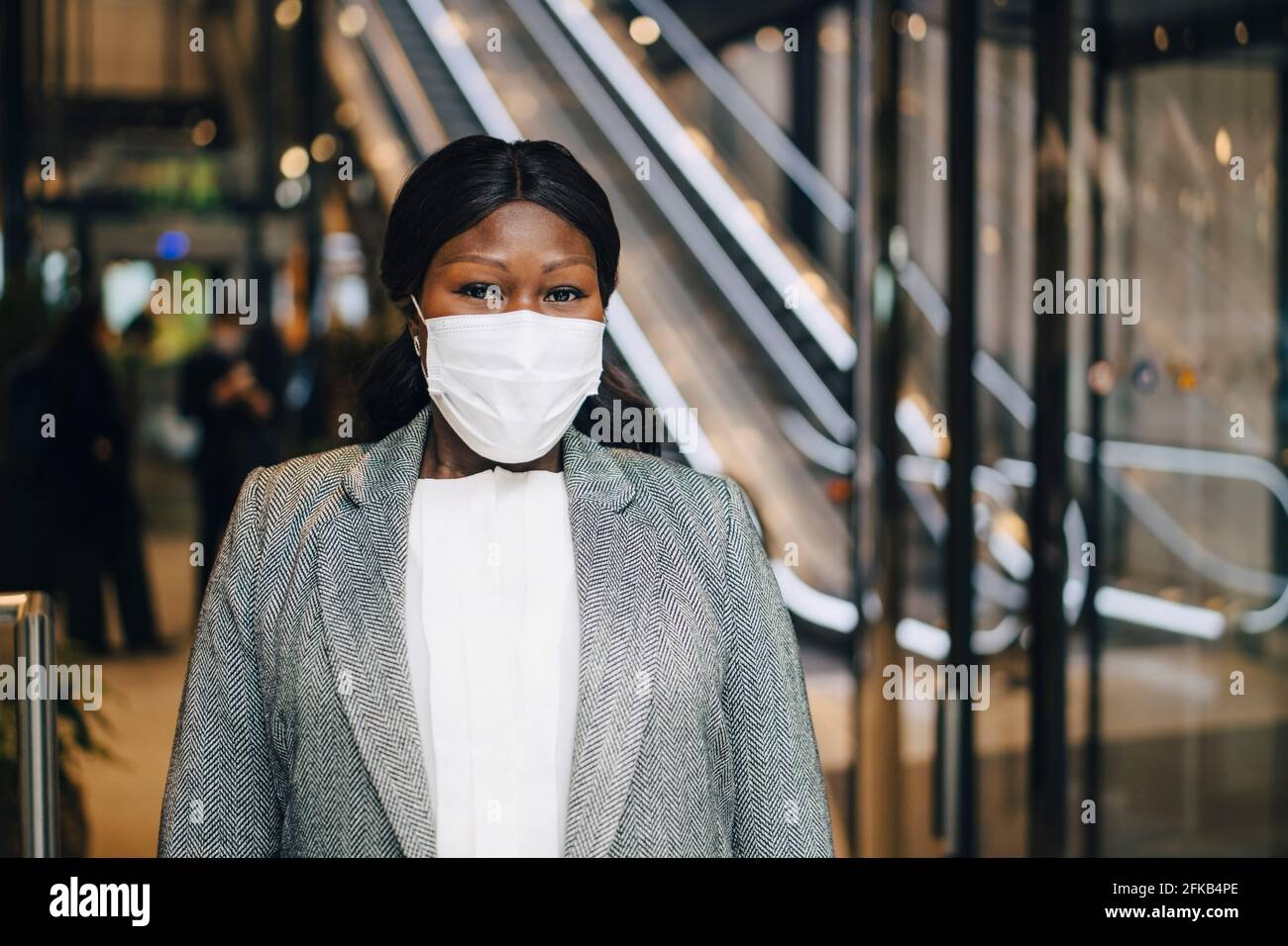 Reife Unternehmerin mit schützender Gesichtsmaske am U-Bahnhof Stockfoto
