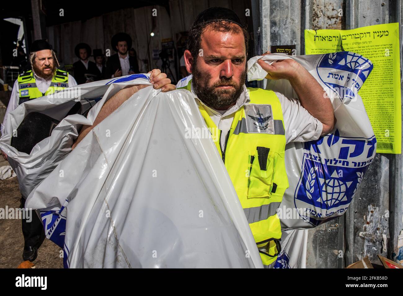 Mount Meron, Israel. April 2021. Israelische Rettungskräfte und Sicherheitsbeamte halten am jüdisch-orthodoxen Wallfahrtsort am Berg Meron Taschen voller persönlicher Gegenstände in der Hand, wo Dutzende von Gläubigen während des jüdischen religiösen Festivals lag Ba'Omer in Nordisraelien am Freitag bei einem Ansturm getötet wurden. Quelle: Ilia Yefimovich/dpa/Alamy Live News Stockfoto