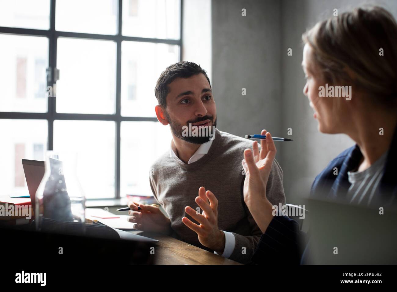 Weibliche Unternehmerin im Gespräch mit männlichen Kollegen im Kreativbüro während Besprechung Stockfoto
