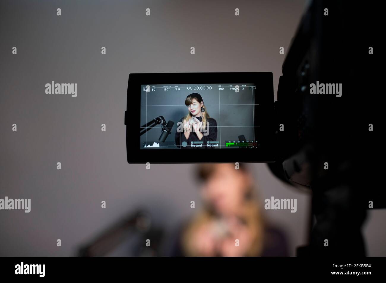 Weibliche professionelle Erklärung durch Videoaufzeichnung vor der Kamera im Büro Stockfoto