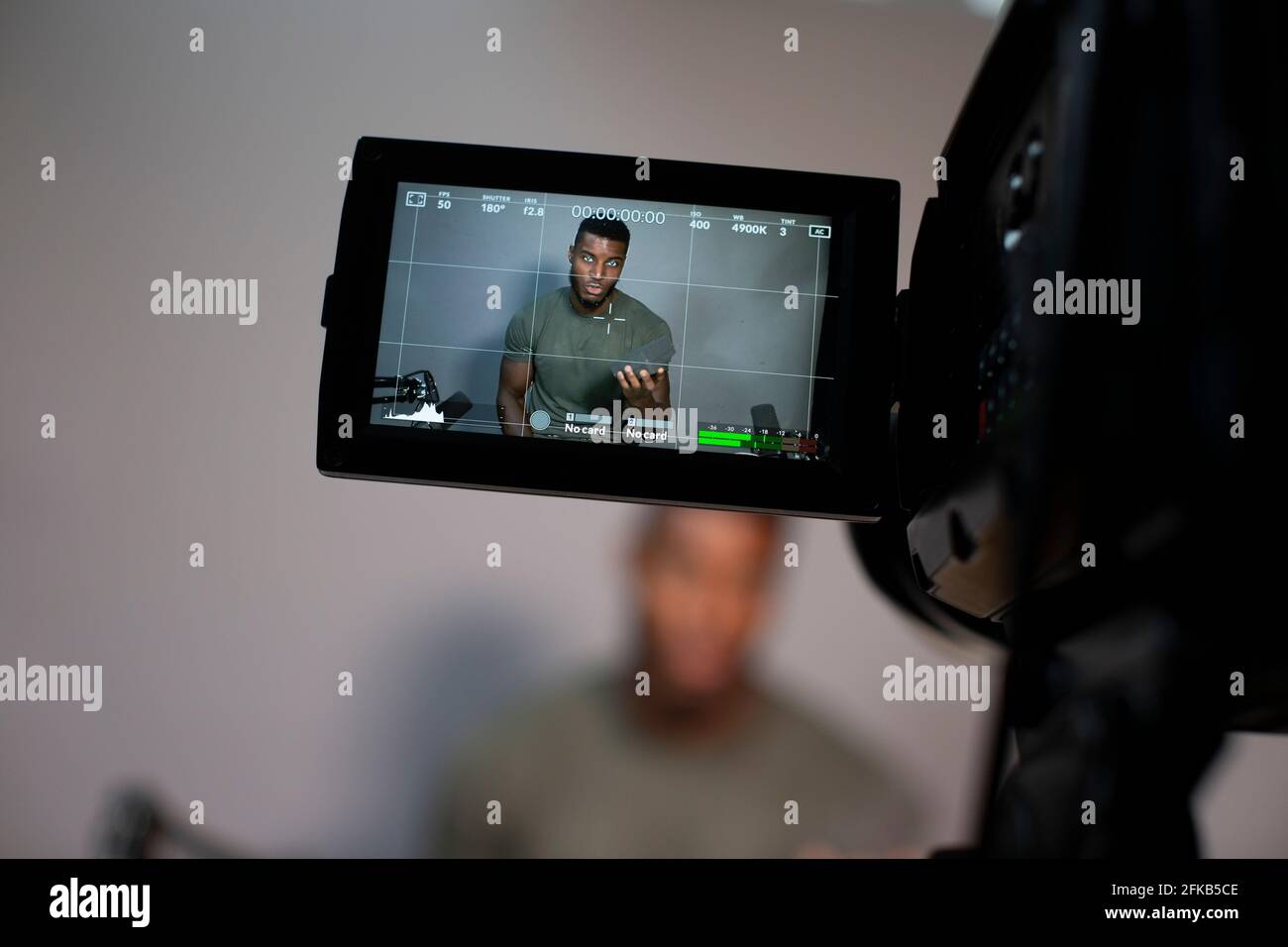 Männlicher Unternehmer, der im Büro ein Video vor der Kamera aufzeichnet Stockfoto