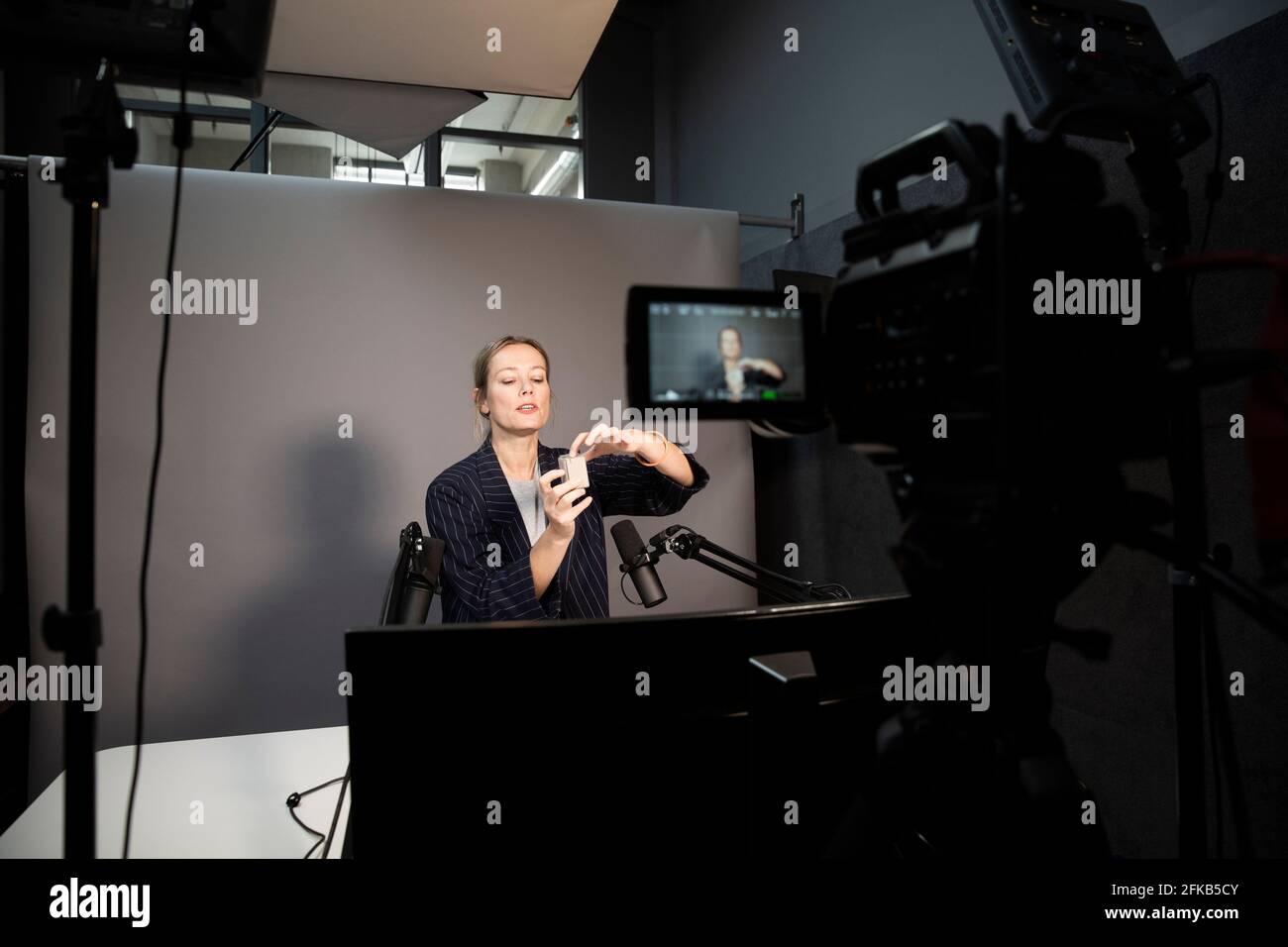 Weibliche Unternehmerin erklärt über Produkt während der Aufnahme durch die Kamera bei Büro Stockfoto