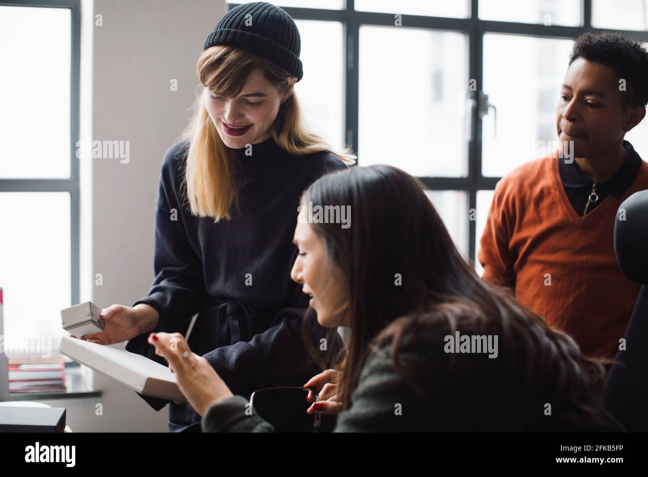 Weibliche und männliche Mitarbeiter diskutieren im Büro über das Produkt Stockfoto
