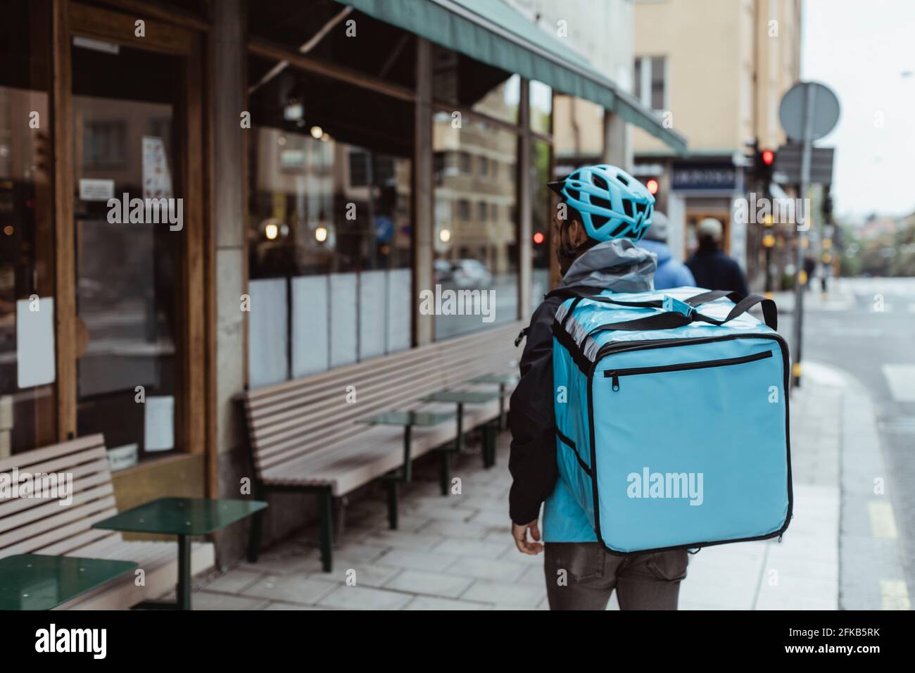 Rückansicht liefern Mann mit Rucksack auf Bürgersteig Stockfoto