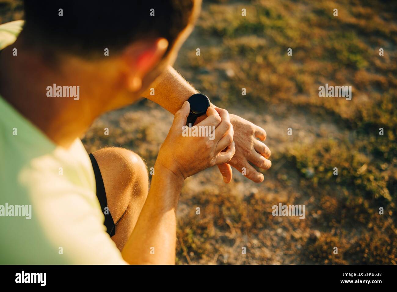 Zugeschnittenes Bild des Sportlers, der die Zeit auf der Armbanduhr überprüft Stockfoto
