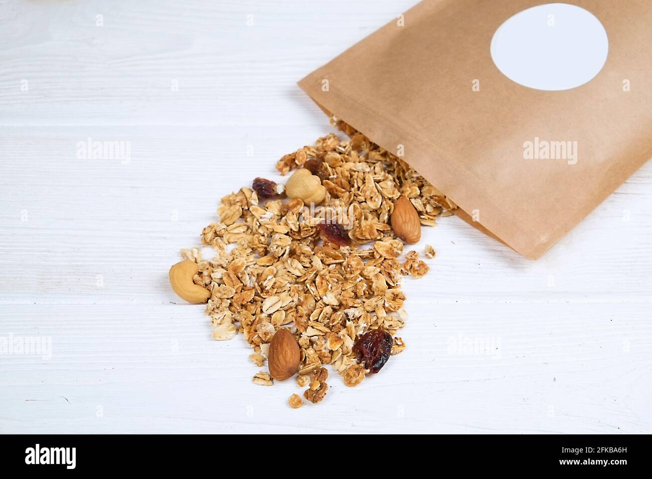 Gemischte Nüsse, trockene Früchte Müsli, Cashew, Mandel, Haselnuss, Rosinen, Preiselbeere auf weißem Holztisch. Gesund nahrhaft vegan Fitness diätetisch super Food Stockfoto