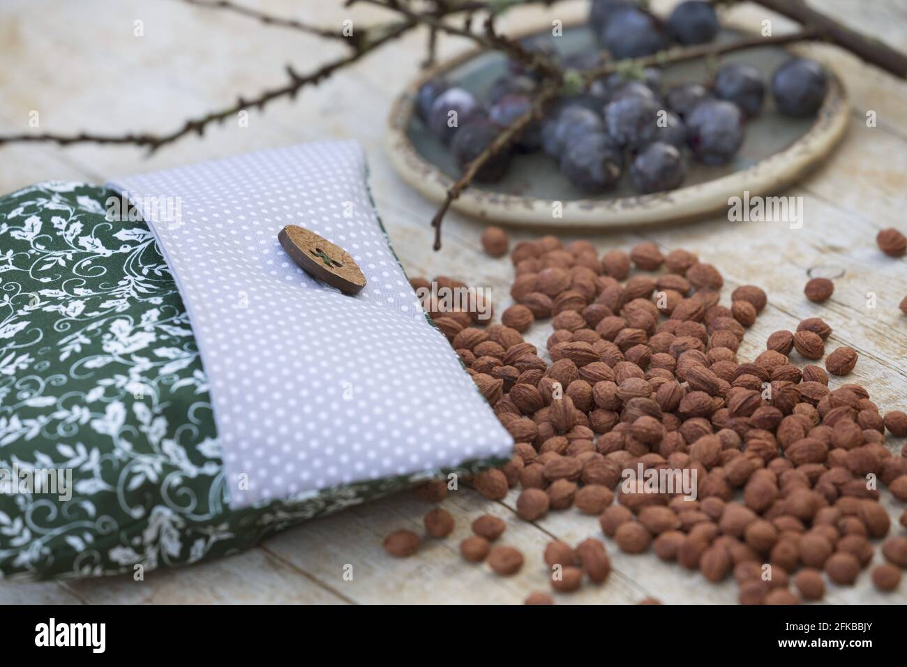 Schlehdorn, Schlehe (Prunus spinosa), Schlehenkernkissen, Schlehenkerne werden in einen Kissenbezug gegeben und bei Bedarf im Ofen erhitzt Stockfoto