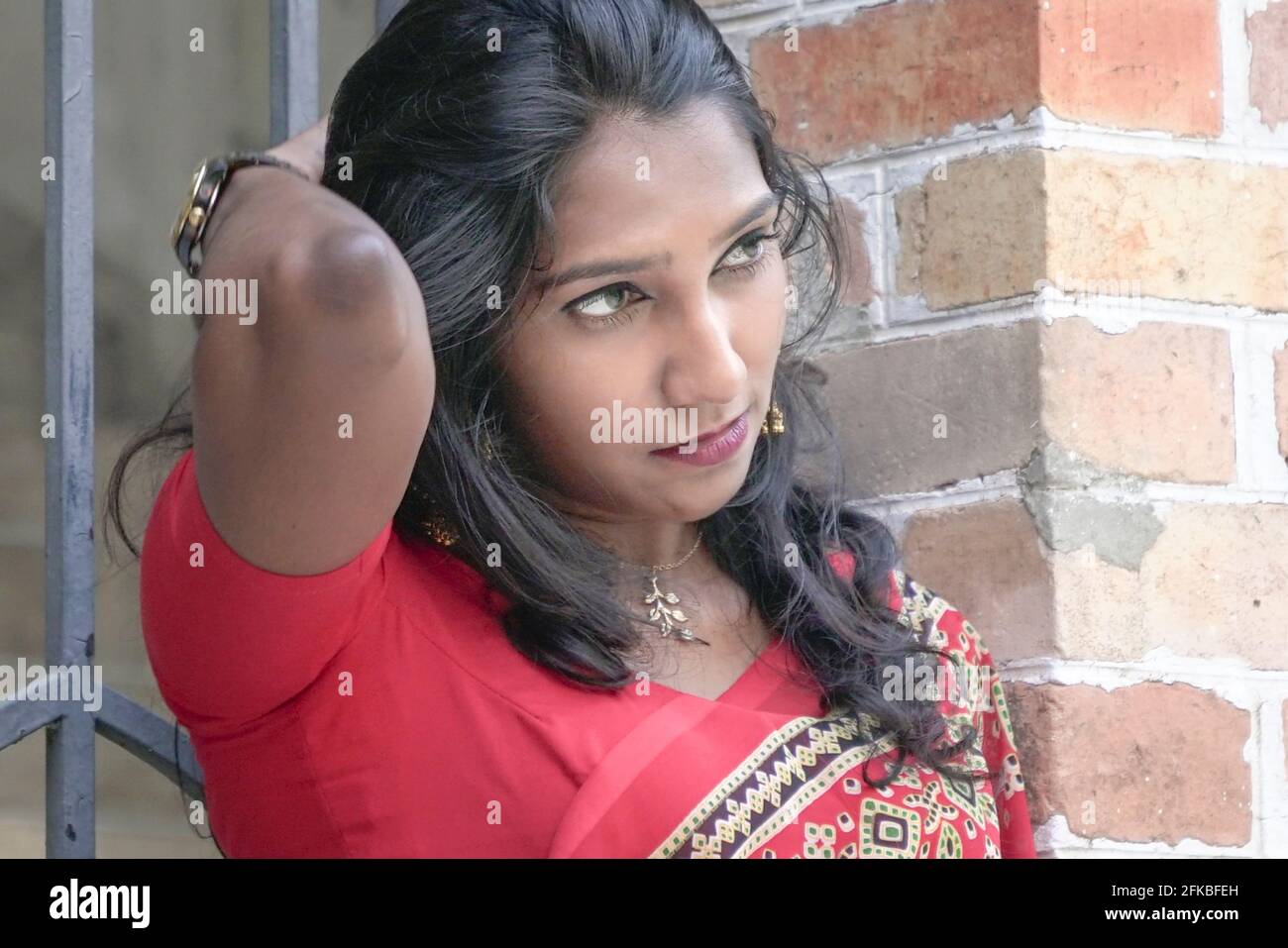 Nahaufnahme einer schönen Inderin mit rotem Saree. Seitenansicht. Stockfoto