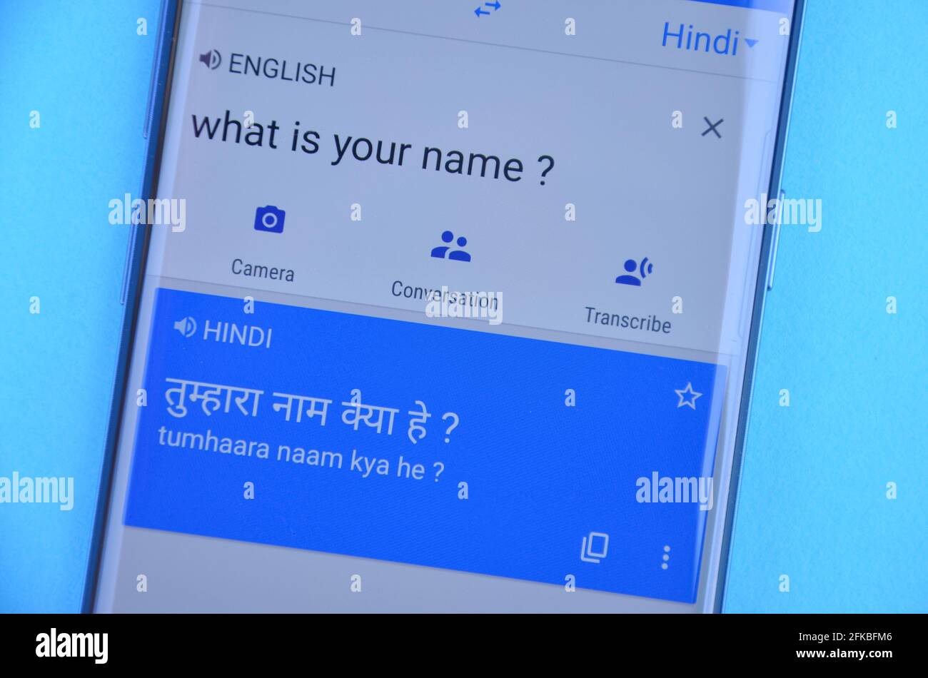 Mandi, Himachal Pradesh, Indien - 03 05 2021: Übersetzung von 'What is your Name' Deutsch nach Hindi auf Google Translate Anzeige auf Handy isoliert auf blauem Hintergrund. Stockfoto