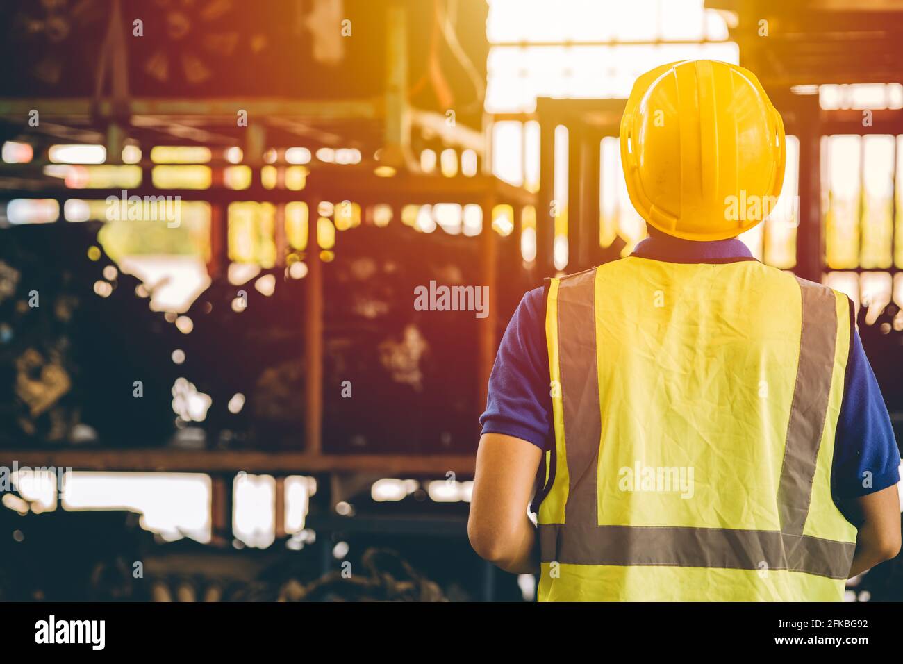 Männliche Ingenieurin Rückansicht Blick auf Regal in schweren Industrie Fabrik Metallarbeiten Stockfoto