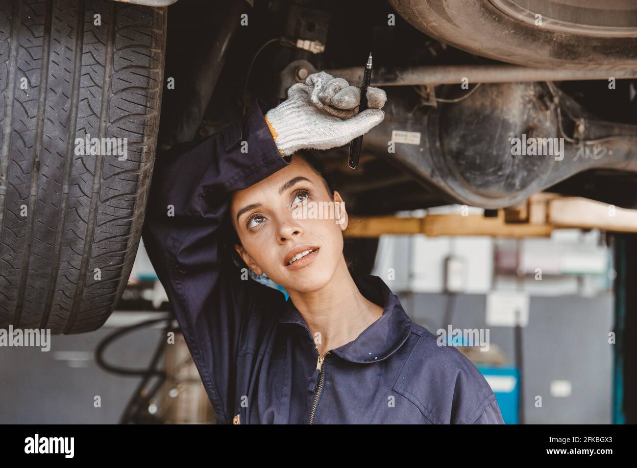 Müde Angestellte harte Arbeit in heißen Gefahrenstelle weg wischen Schweiß arbeiten in Auto-Service-Garage. Stockfoto