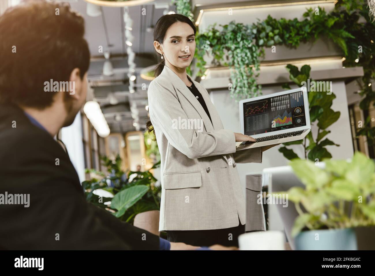 Smarte Frauen glücklich Präsentation Sie oder Bericht Arbeit repräsentieren mit männlichen Teamarbeit in modernen Büro. Stockfoto