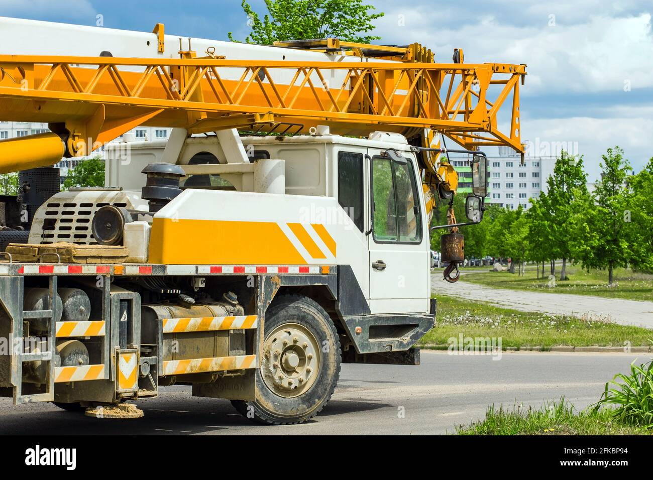 Der industrielle maschinelle Transport von schweren Fahrzeugen fährt in ein städtisches Gebiet auf der Baustelle. Stockfoto