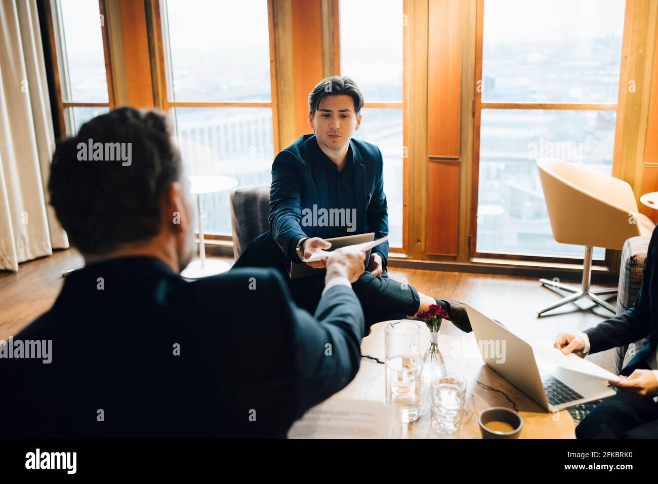 Männliche Kollegen diskutieren über Dokument im Büro Stockfoto