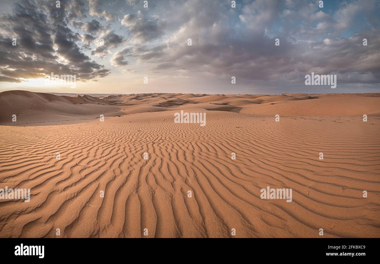 Sanddünen bei Sonnenuntergang in der Wahiba Sandwüste mit Wolken am Himmel, Oman, Mittlerer Osten Stockfoto