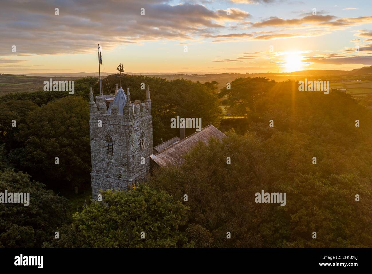 St. Dennis Parish Church, die bei Sonnenaufgang im Herbst von Bäumen auftaucht, St. Dennis, Cornwall, England, Vereinigtes Königreich, Europa Stockfoto