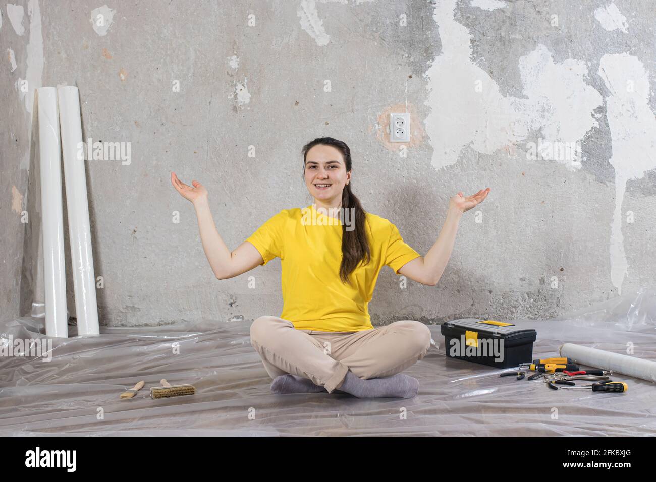 Eine Baumeisterin repariert das Haus. Reparieren von Schlüssel, Kitt und Tapete Stockfoto