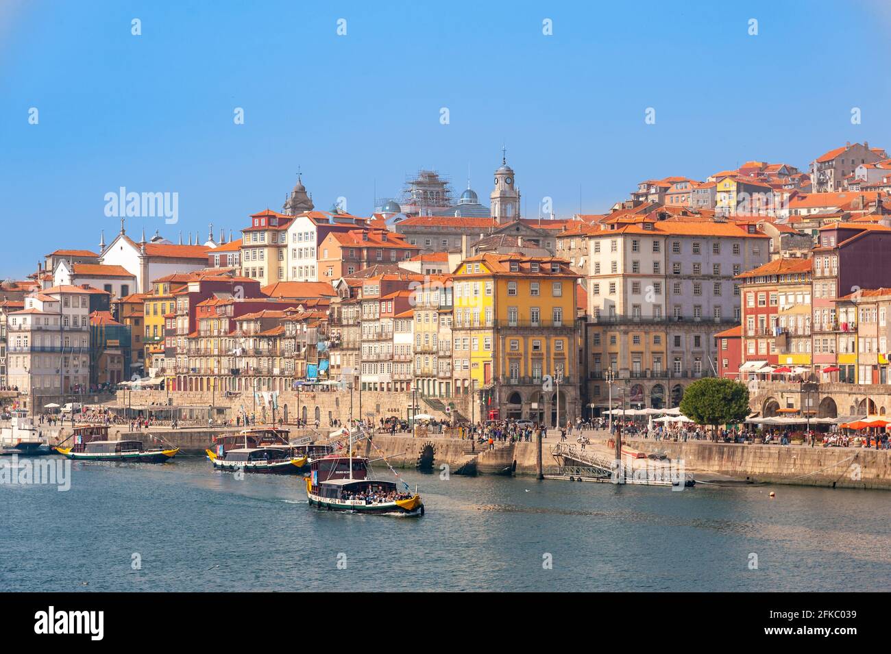 Rabelo-Boote fahren entlang der Uferpromenade des Douro-Flusses im Stadtzentrum von Porto, Portugal Stockfoto