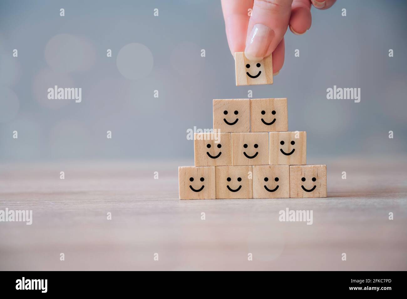 Beste Bewertung von exzellenten Business-Services, Customer Experience-Konzept. Hand Putting Holzwürfelblock mit Happy Face Smiley-Symbol. Zufriedenheitsumfrage Stockfoto
