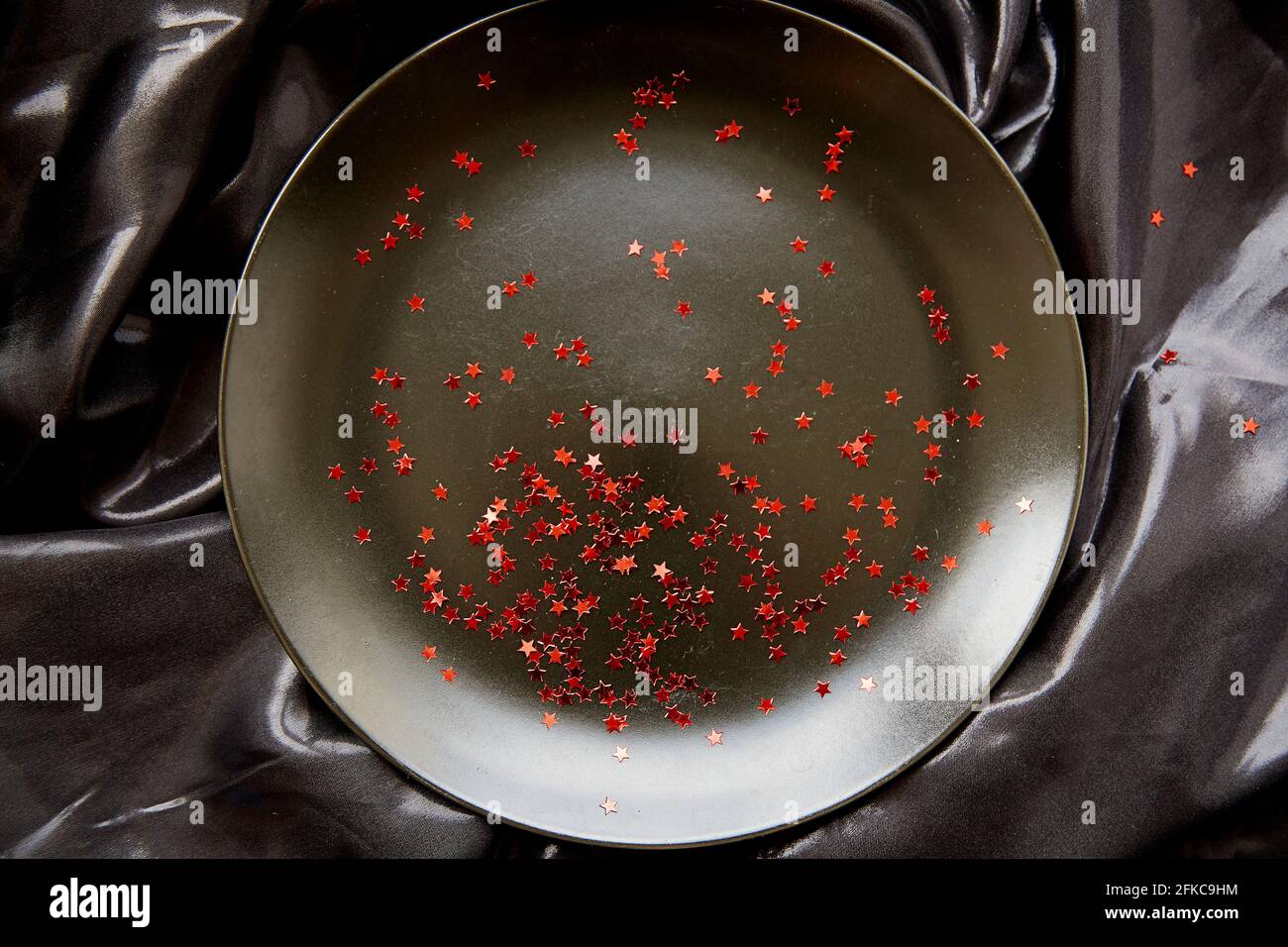 Luxus schwarzen Hintergrund mit Platz für die Werbung mit leuchtend roten festlichen Sternen. Karte für Unternehmen. Elegante Geburtstagskarte. Minimalistisches Konzept. Modischer Style. Draufsicht Stockfoto