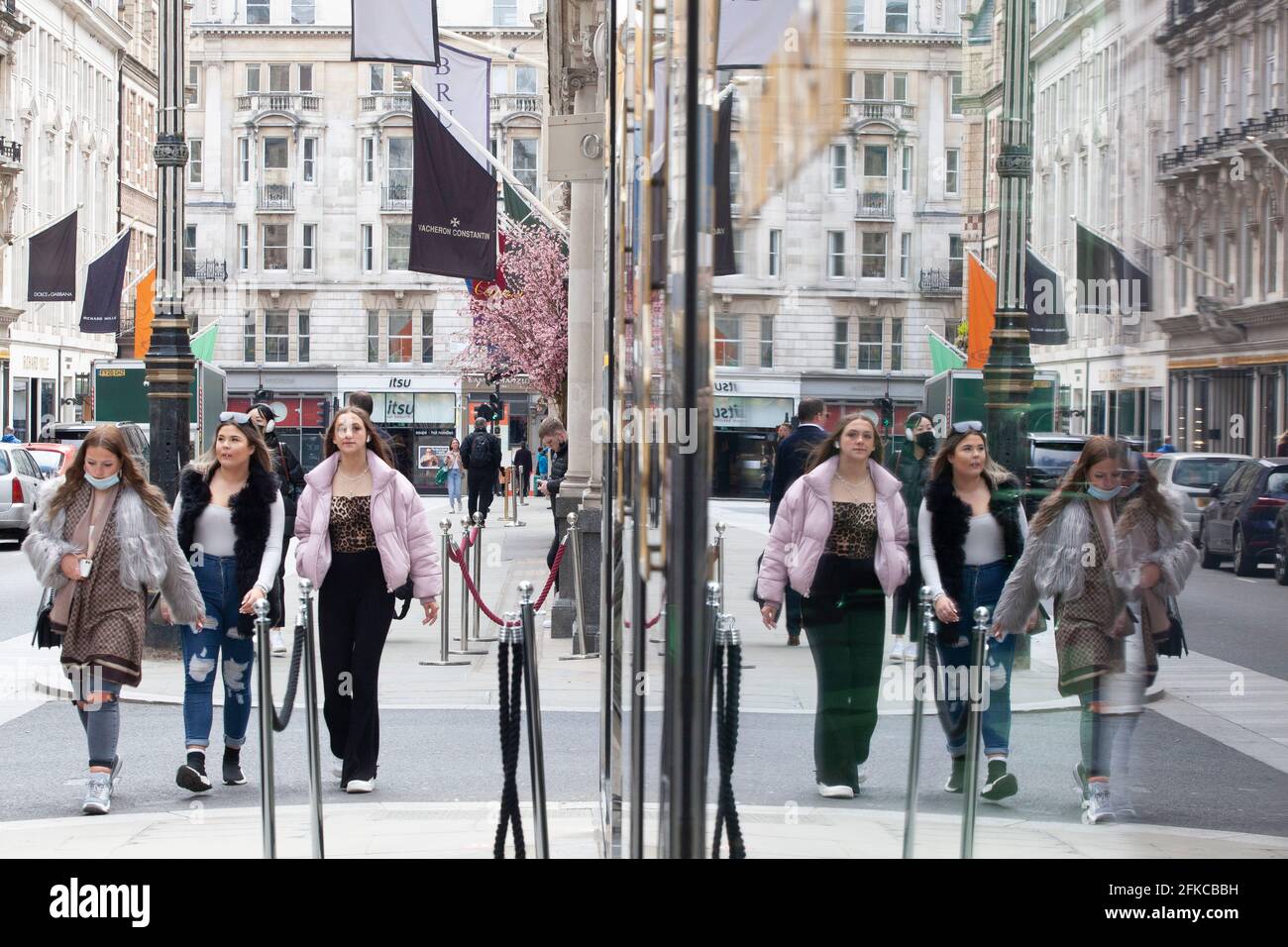 London, Großbritannien, 30. April 2021: In den Schaufenstern des Yves St Laurent-Stores spiegeln sich die Käufer in den Luxusboutiquen der Bond Street wider. Anna Watson/Alamy Live News Stockfoto