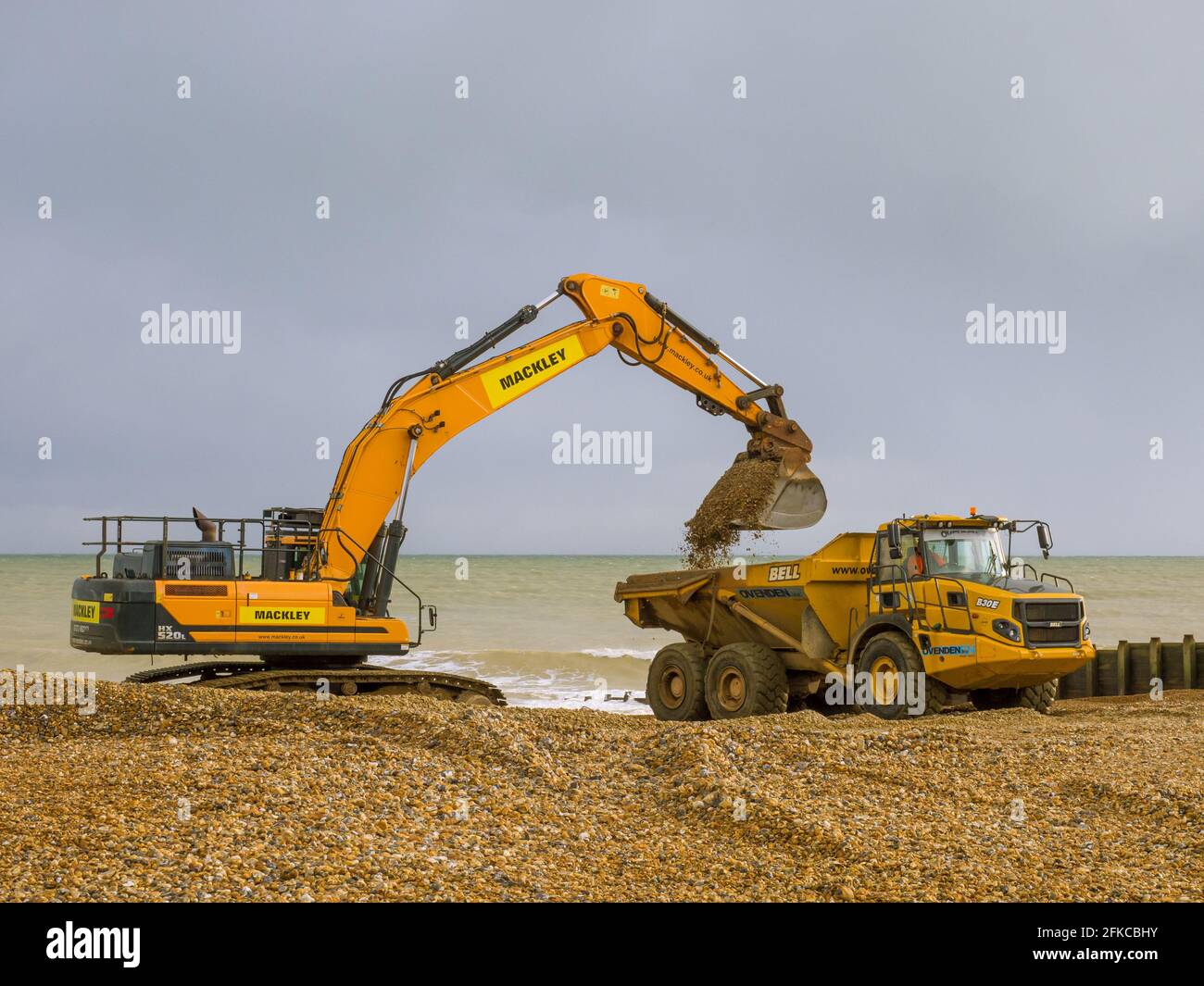 Schwere Anlage am Strand von Eastbourne in East Sussex, Großbritannien. Das Verschieben von Kies aus einem gebebten Bereich des Strandes. Stockfoto