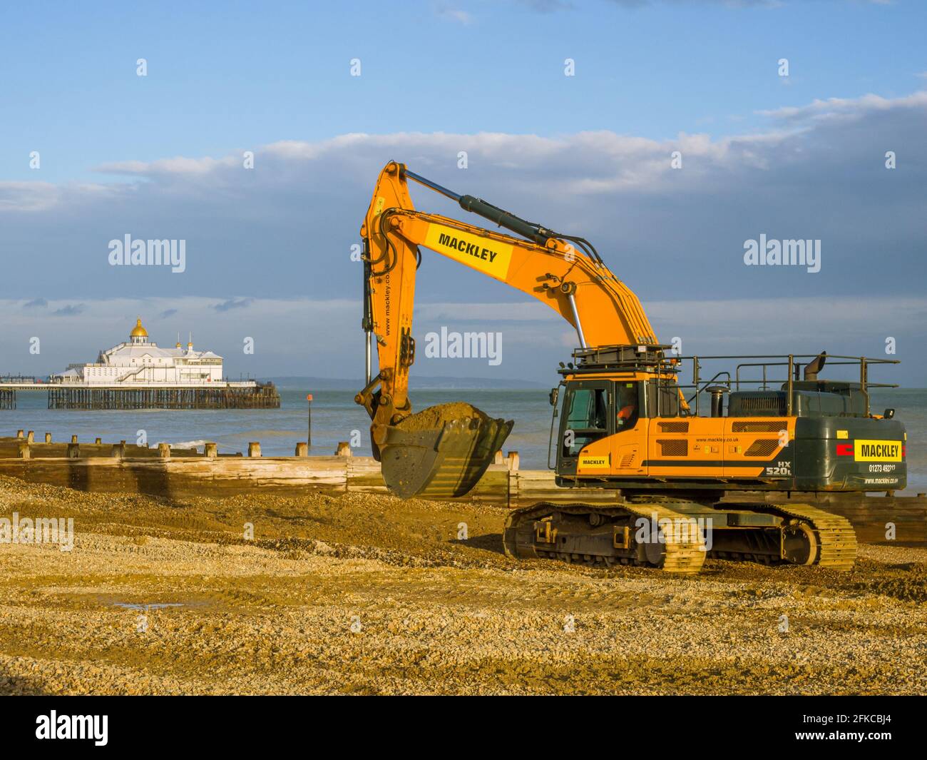 Schwere Anlage am Strand von Eastbourne in East Sussex, Großbritannien. Das Verschieben von Kies aus einem gebebten Bereich des Strandes. Stockfoto