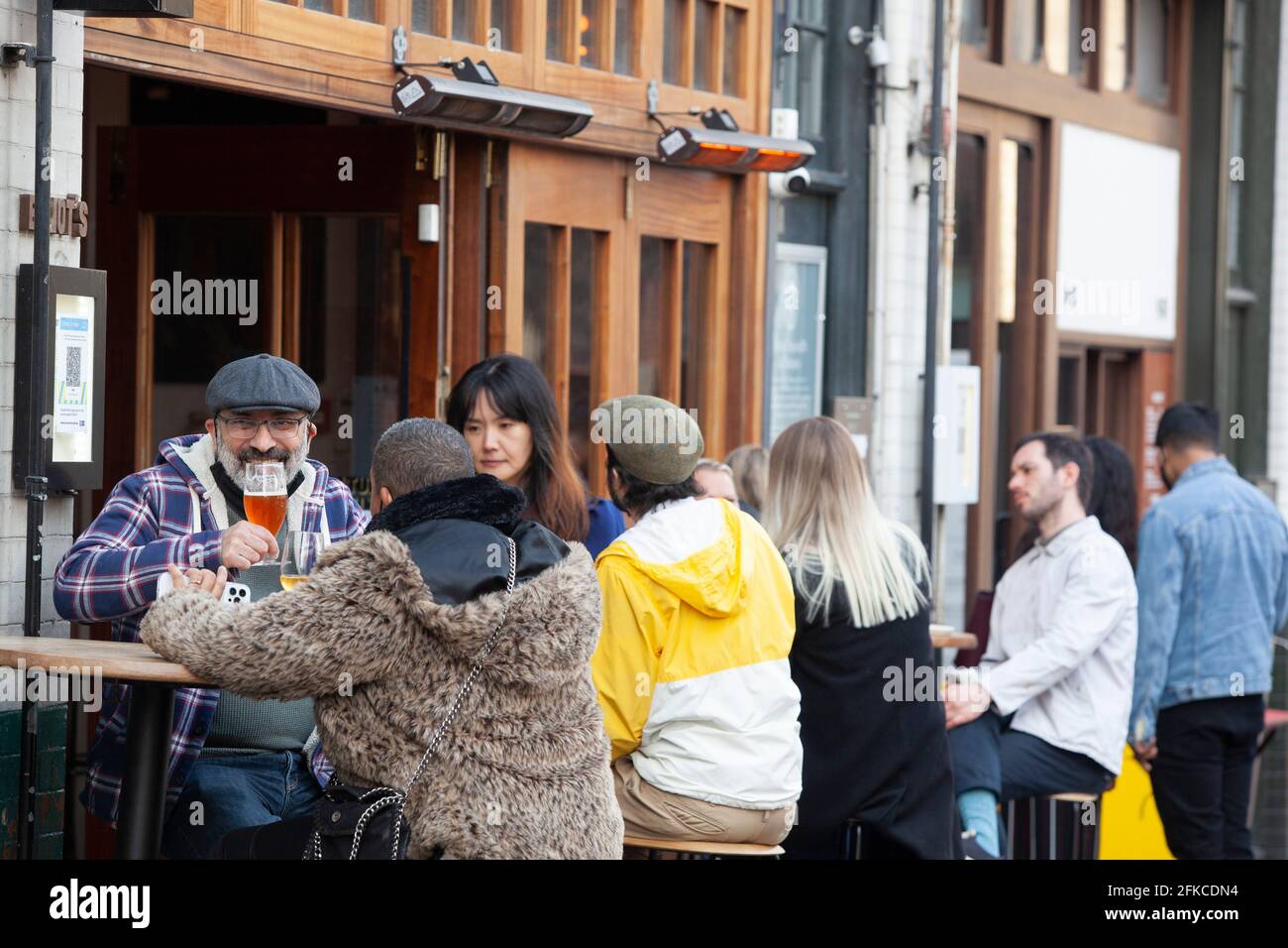 London, Großbritannien. April 2021. Die Restaurants auf dem Borough Market beherbergen an einem kalten, sonnigen Tag Gäste und Trinker. Einige sind offen für Drop-in-Kunden, während andere eine Reservierung und eine Temperaturkontrolle benötigen. Obwohl das Wetter für die Jahreszeit kälter als üblich ist, blieb es trocken genug, damit die Gäste ihre Mahlzeiten genießen konnten. Quelle: Anna Watson/Alamy Live News Stockfoto