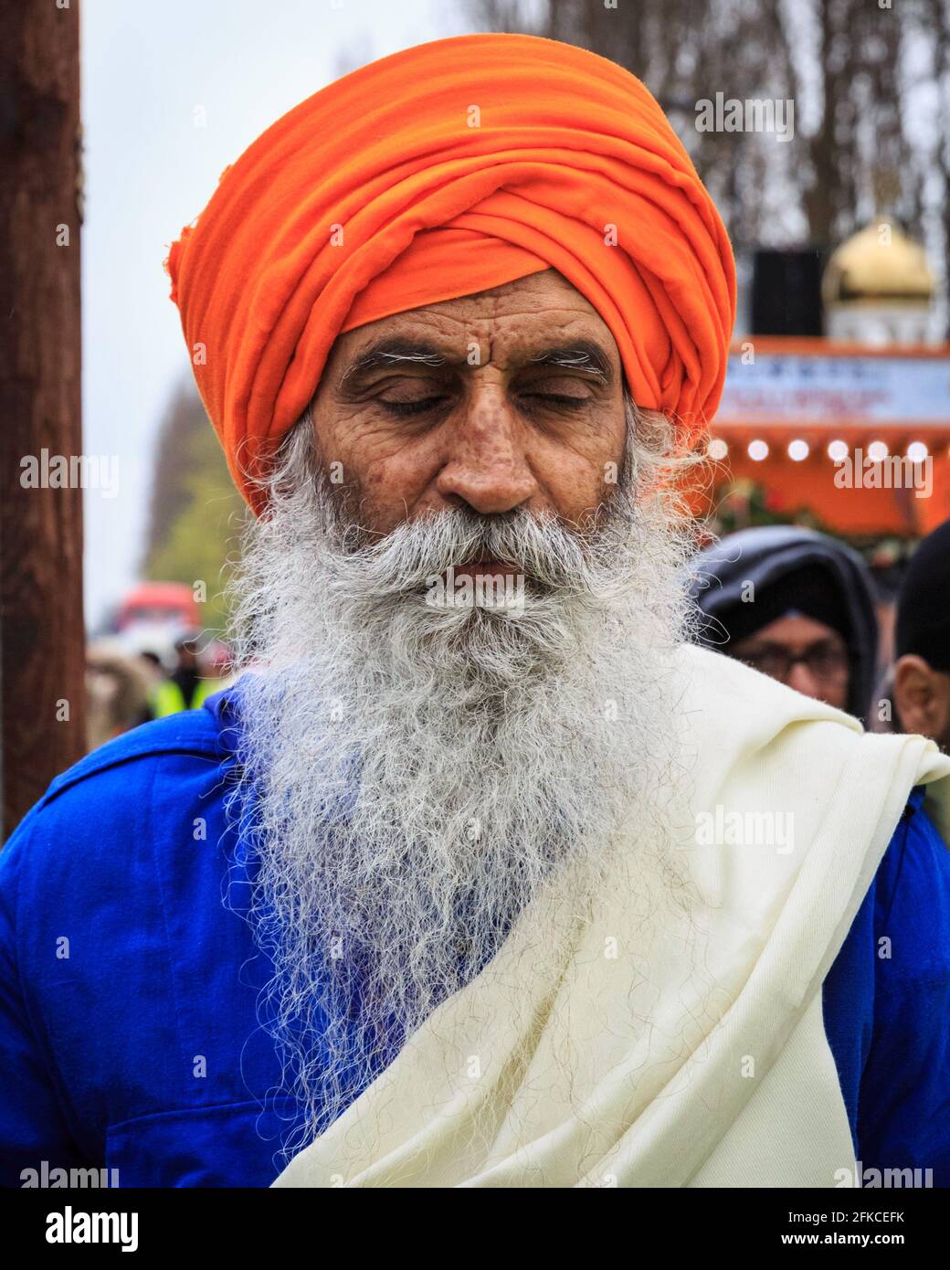 Porträt Sikh-Mann in orangefarbenem Turban (dastar) und Bart in Vaisakhi, Southall, London Stockfoto