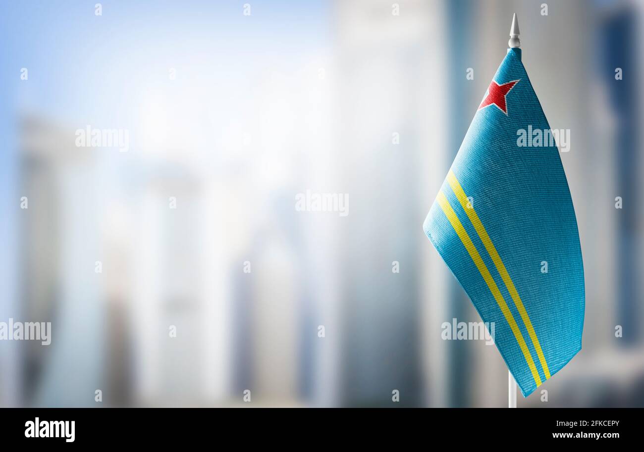 Eine kleine Flagge von Aruba auf dem Hintergrund eines unscharfen Hintergrunds Stockfoto