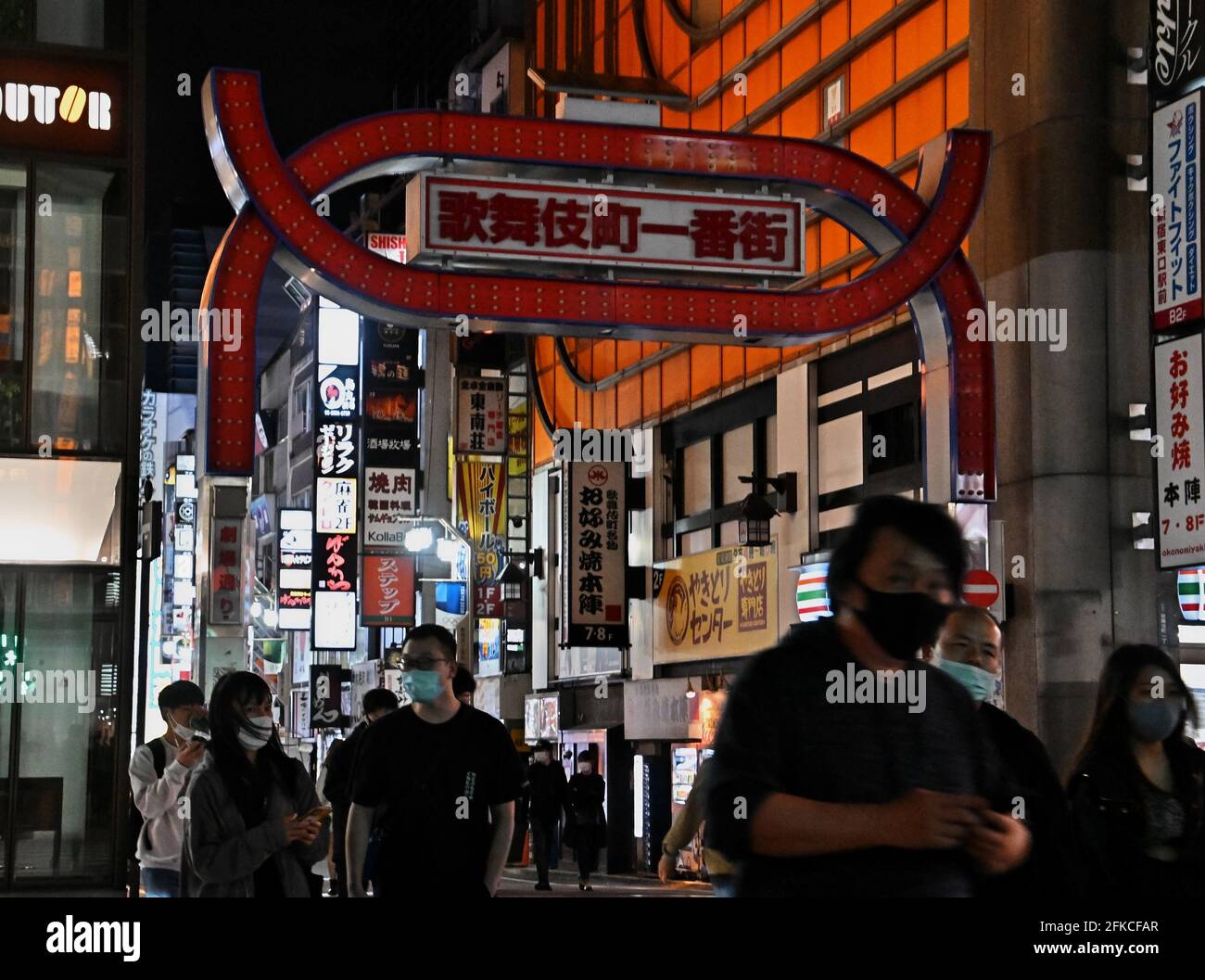 Tokio, Japan. April 2021. Fußgänger mit Gesichtsmasken gehen am Freitag, den 30. April 2021, im Einkaufs- und Unterhaltungsviertel Kabukicho in Tokio, Japan, spazieren. Der Gouverneur von Tokio, Yuriko Koike, fordert während des dritten Ausnahmezustands für COVID-19 vom 25. April bis 11. Mai, die Neonschilder nach 8 Uhr auszuschalten. Foto von Keizo Mori/UPI Credit: UPI/Alamy Live News Stockfoto