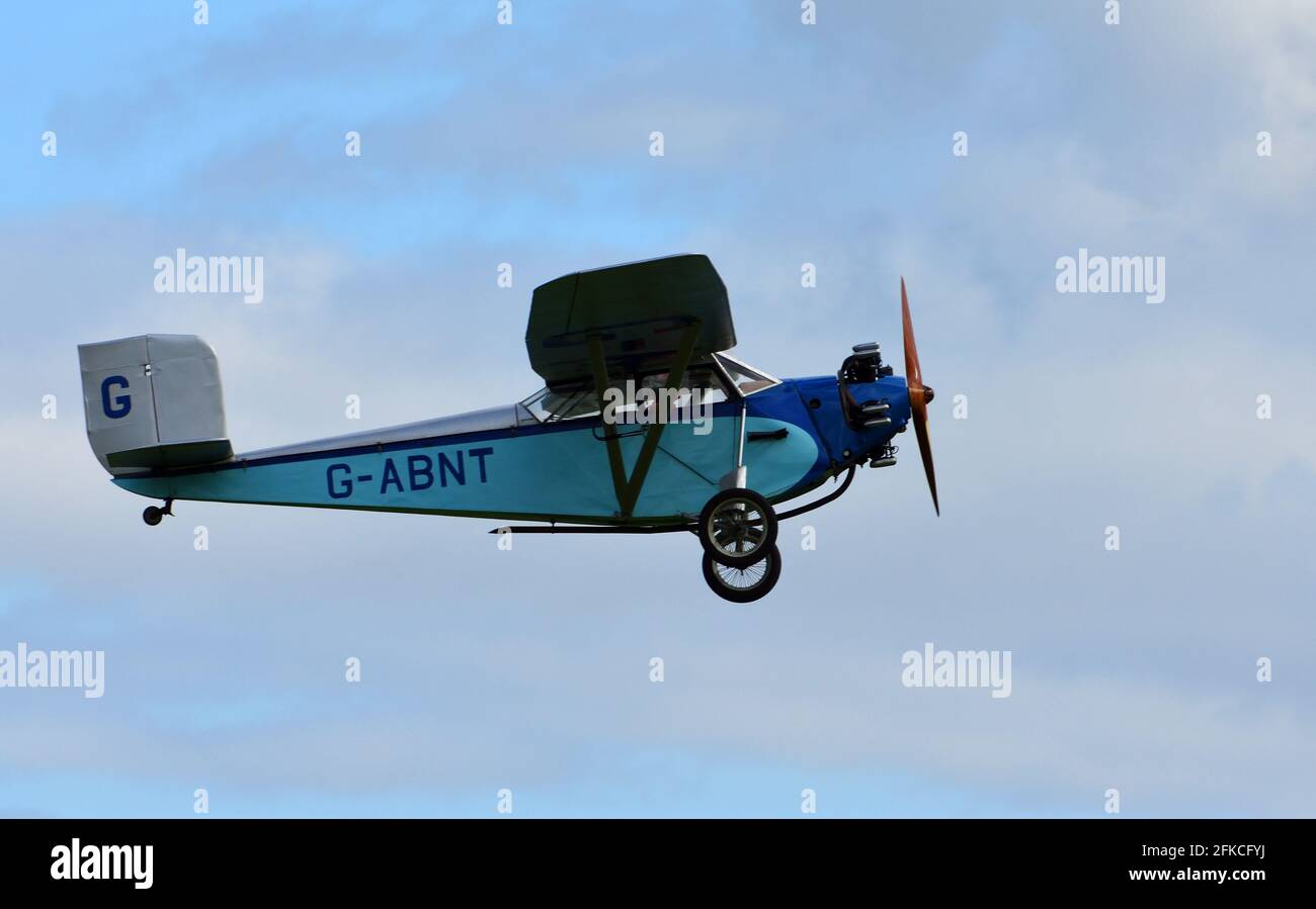 Jahrgang 1931 Civilian Coupe 02 G-ABNT Flugzeug im Flug mit blauem Himmel und Wolken. Stockfoto