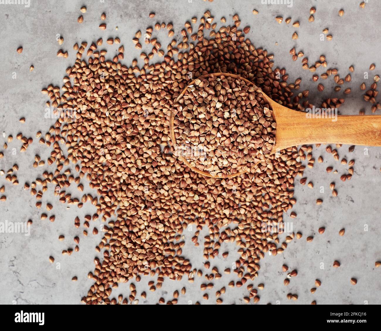 Roher Buchweizen in einem Holzlöffel. Organische Vollkornprodukte. Stockfoto