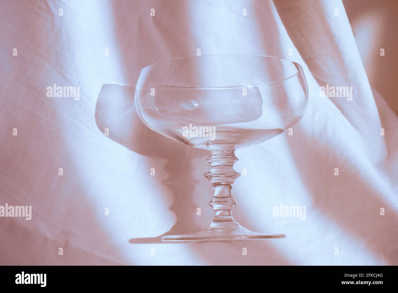 Ein Champaign-Glas auf einem weißen Blatt mit Schatten . Isoliert. Stockfoto