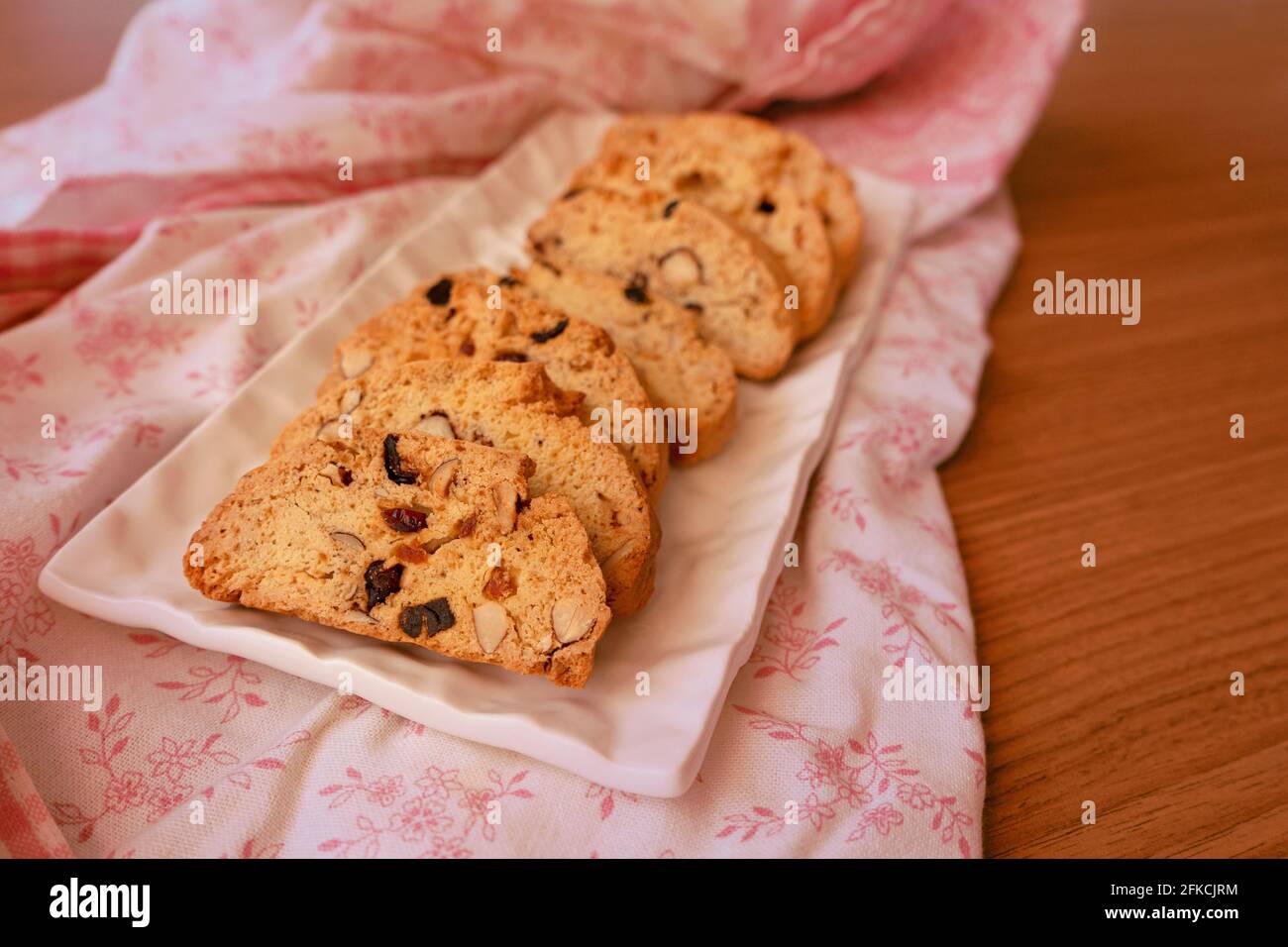 Frisch gekochte Biscotti-Kekse auf einem floralen Appron. Perfekt für die Nachmittagsferien Stockfoto