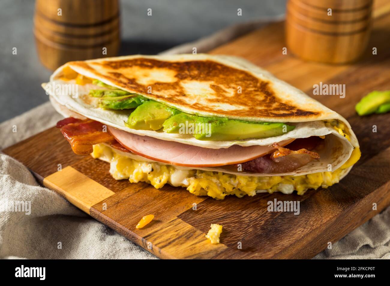 Hausgemachtes, trendiges Ei-Tortilla-Frühstücksandwich mit Schinken und Avocado Stockfoto