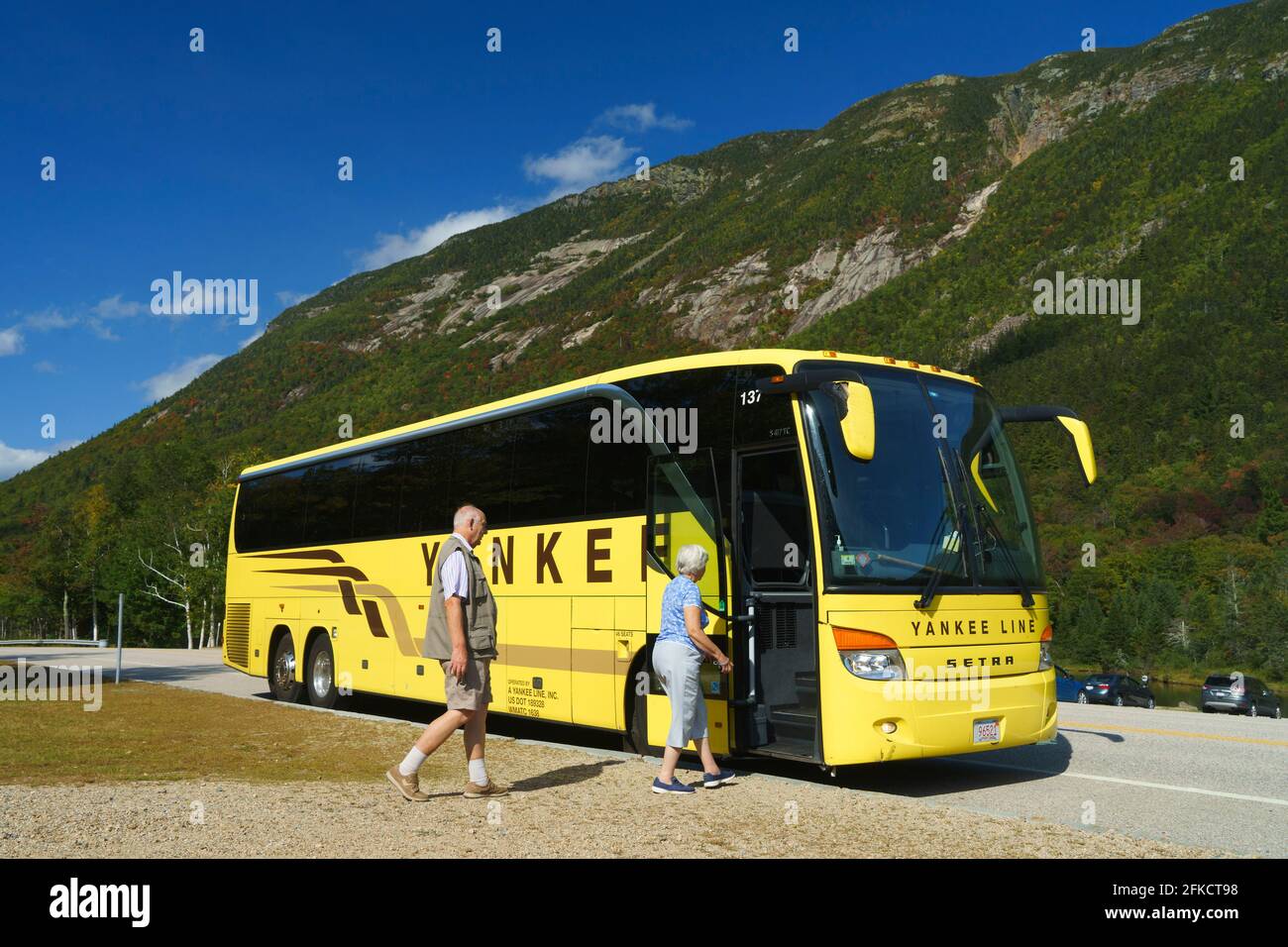 Ein paar ältere Touristen steigen in einen Yankee Line-Reisebus ein. Stockfoto
