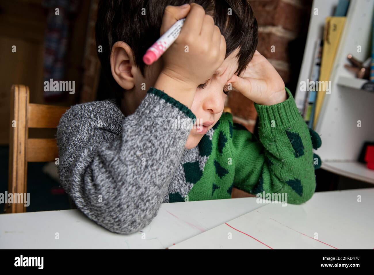 Großbritannien, frustrierter Junge, der Hausaufgaben macht Stockfoto