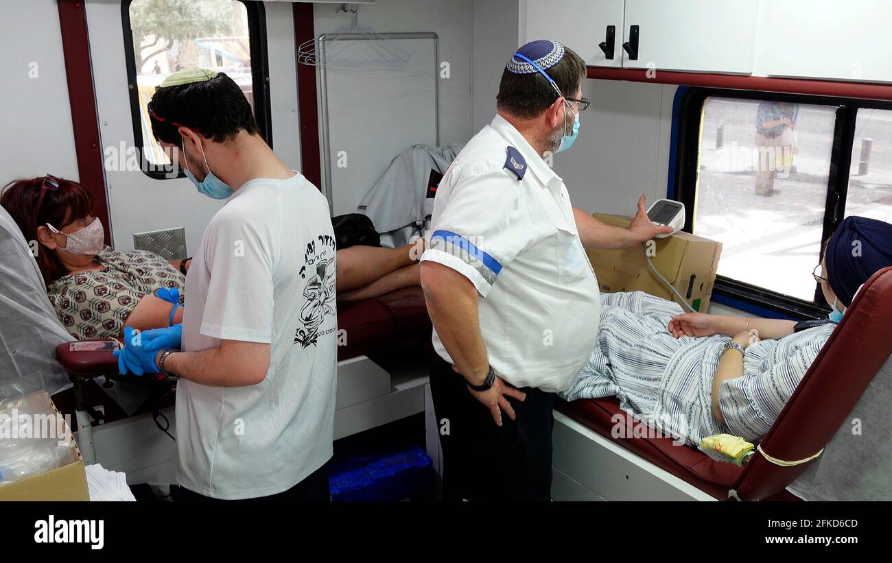 Israelische Frauen spenden Blut in einem Blutspendefahrzeug nach der Katastrophe am Berg Meron auf lag Ba'omer, bei der am 30. April 2021 in Jerusalem, Israel, mindestens 44 Menschen getötet wurden. Die Blutspendestationen des nationalen medizinischen Notdienstes „Magen David Adom“ in Israel haben eine überwältigende Reaktion der Öffentlichkeit gemeldet, wobei viele an den Stationen aufkamen, um Blut zu spenden. Stockfoto