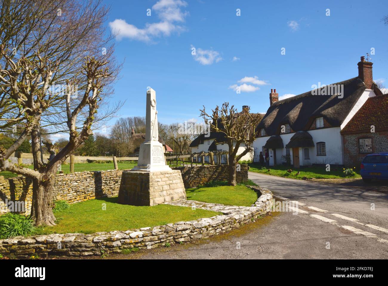 Kriegsdenkmal und strohgedeckte Hütten im Dorset-Dorf von Tarrant Monkton Stockfoto