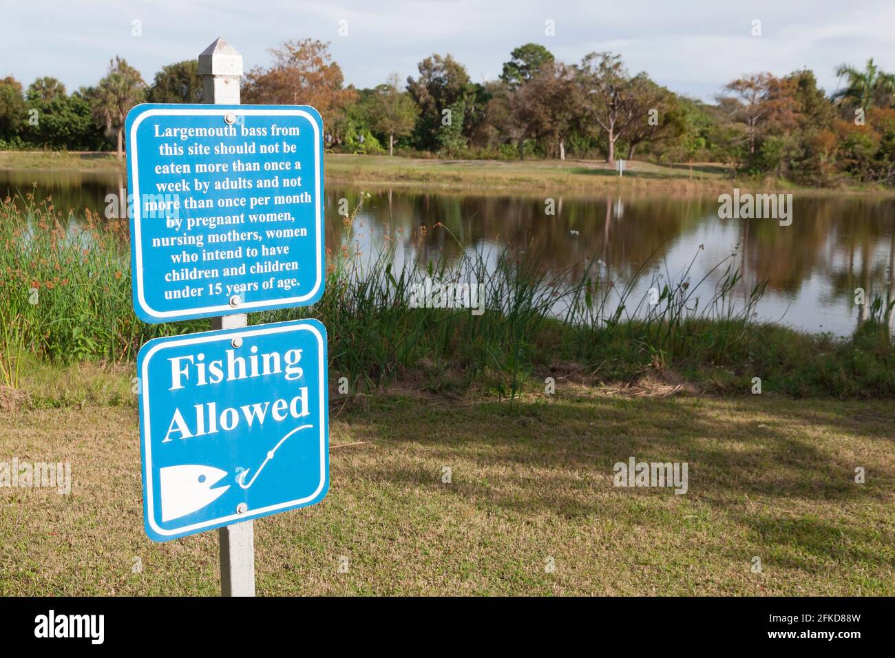 Schild erlaubt Angeln und Warnung über den Verzehr von Forellenbarschen zu häufig. Stockfoto
