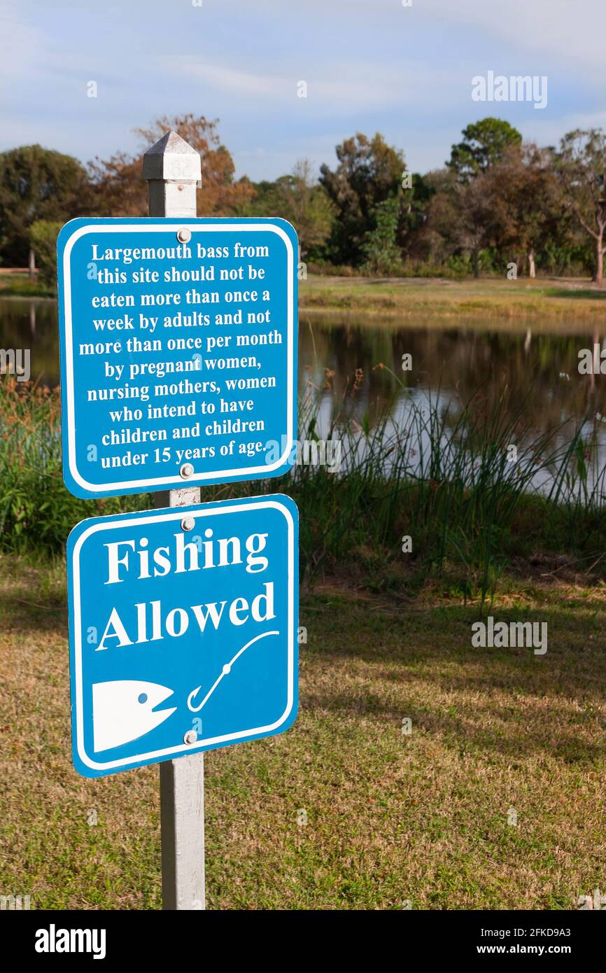 Schild erlaubt Angeln und Warnung über den Verzehr von Forellenbarschen zu häufig. Stockfoto