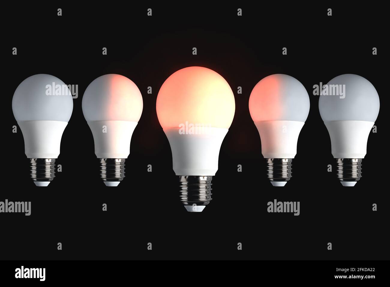 Rote Glühlampe auf schwarzem Hintergrund. Idee, Kreativität, Energie, Erfindung, Innovation, Einfluss, Führungskonzept. Stockfoto