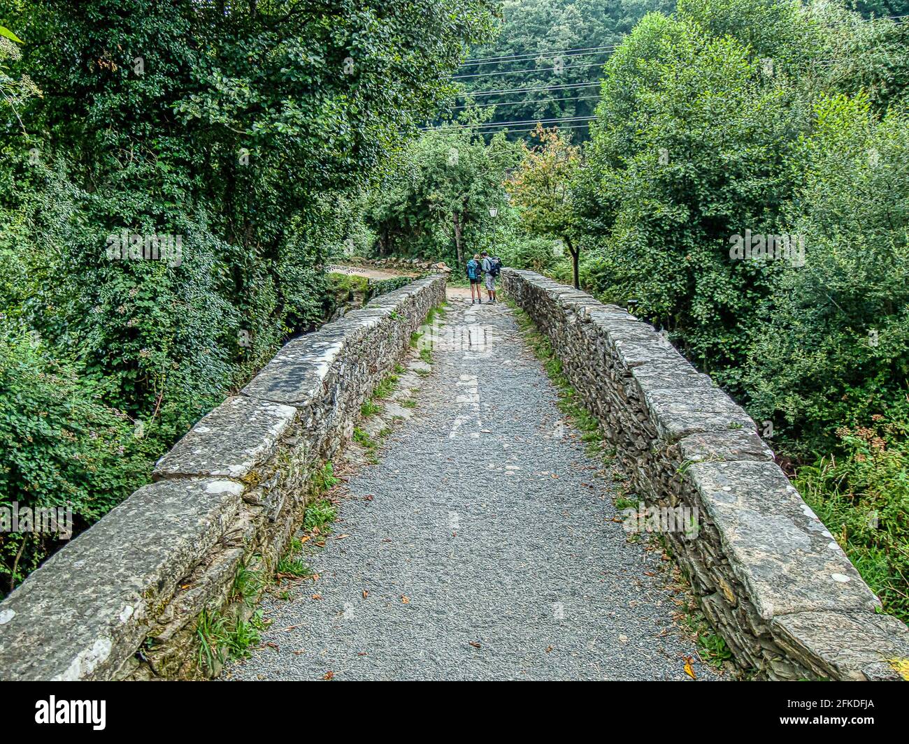 Pilger auf dem camino auf der mittelalterlichen Brücke puente Aspera, in Sarria, Spanien, 21. Juli 2010 Stockfoto Pilger auf dem camino auf der mittelalterlichen Brücke puente Aspera, in Sarria, Spanien, 21. Juli 2010 Stockfoto