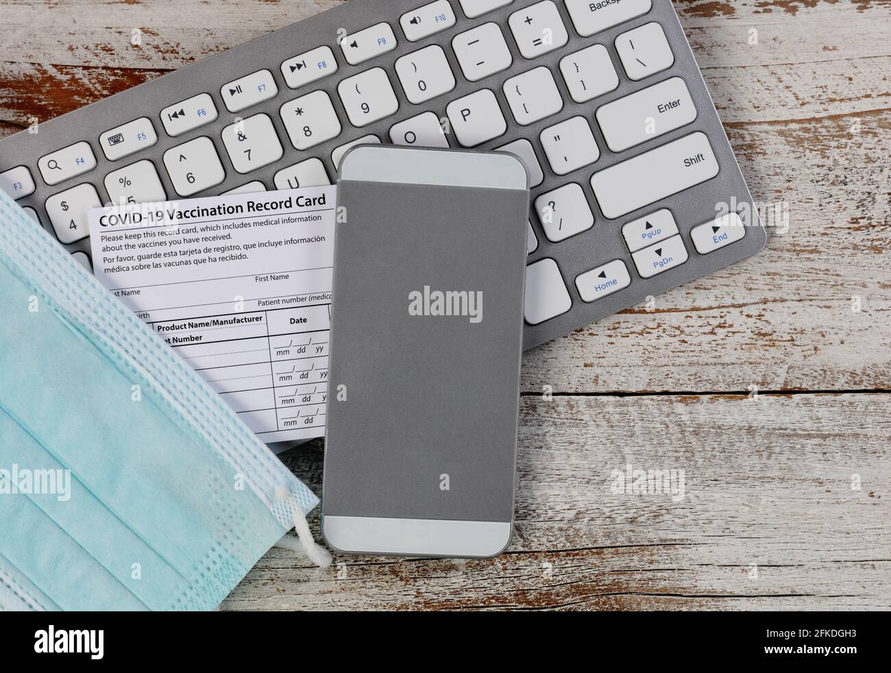 Nahaufnahme der Impfkarte Covid 19 für die Rückkehr zur Arbeit oder zur Schule auf einem weißen Schreibtisch aus Holz. Individueller Datensatz zur Verwendung Stockfoto