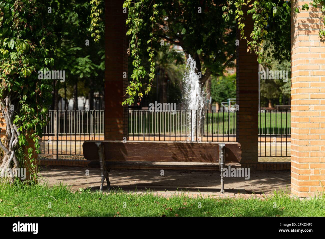 Brunnen, Bank und Kletterpflanze in einem schönen grünen Stadtpark. Valencia, Spanien Stockfoto