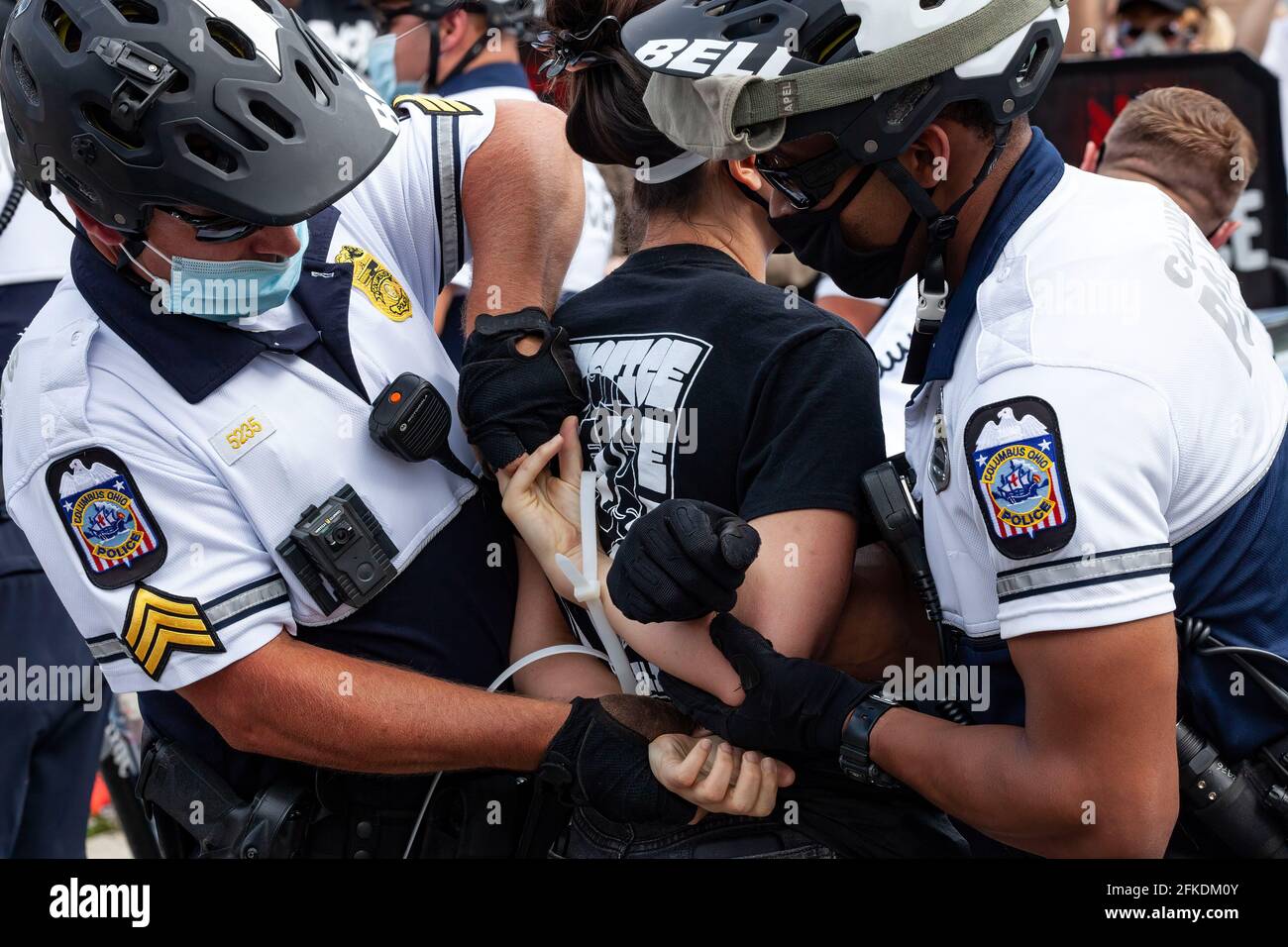 Polizeibeamte von Columbus binden einen Aktivisten der Black Lives Matter an, der die Inhaftierung von Autos verhinderte, die den Parkplatz des brüderlichen Polizeiordens blockierten. Aktivisten von Black Lives Matter protestierten auf dem Parkplatz des brüderlichen Polizeiordens gegen die Brutalität der Polizei und blockierten bestimmte Eingänge zu den Parkplätzen mit Autos. Die Polizeibeamten von Columbus begannen nach einer gewissen Zeit, Autos zu schleppen, die die Eingänge zu Parkplätzen und Straßen blockierten. Einige Demonstranten wurden verhaftet und mit Pfeffer gespritzt, um die Inhaftierung der Autos zu verhindern. Stockfoto