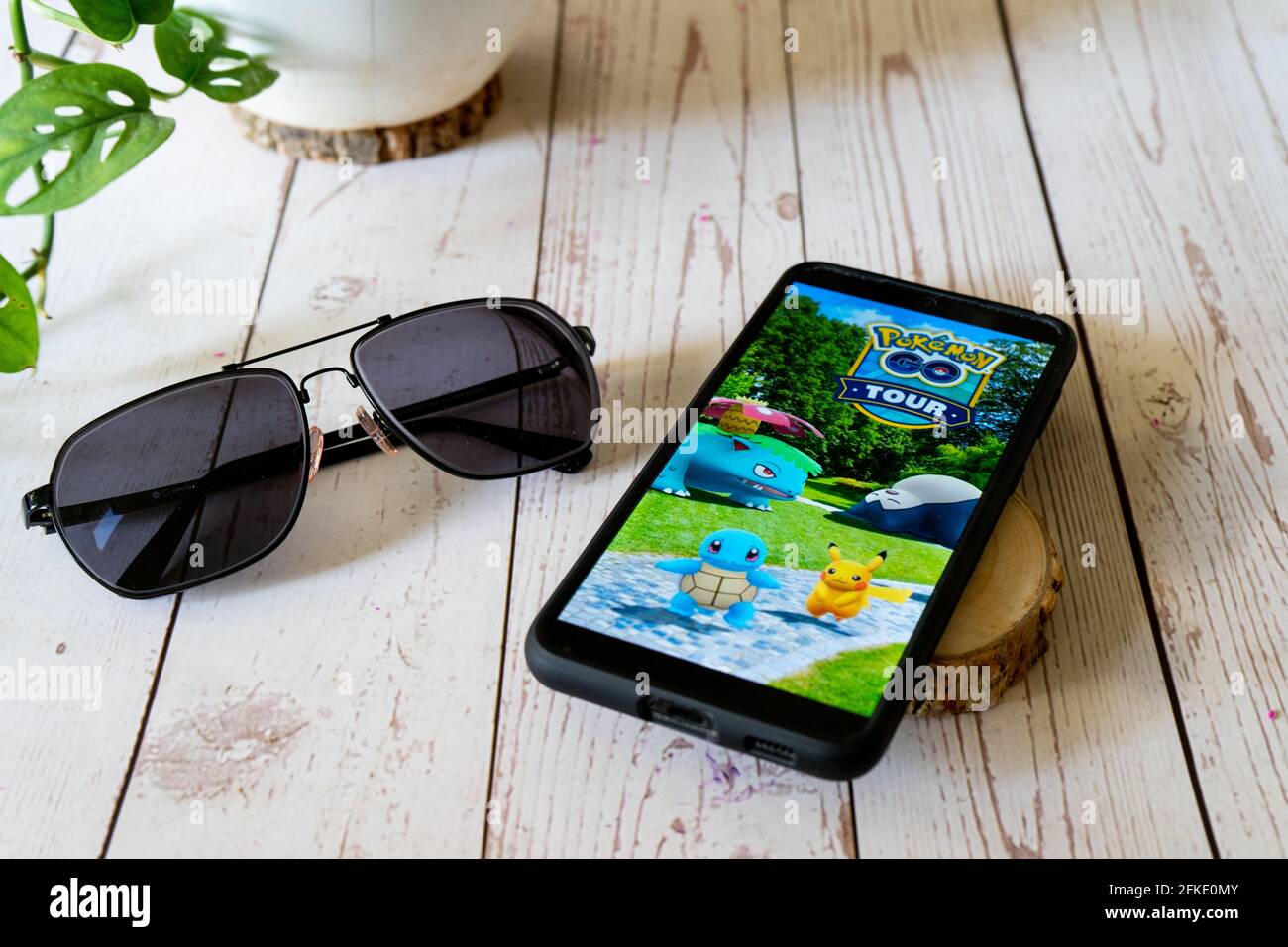 Berühmte Augmented Reality virtuelles Spiel pokemon gehen Tour spielen auf  Ein Mobiltelefon auf einem Holztisch im Freien mit Pflanzen Brillen, die  den Menschen Freude machen Stockfotografie - Alamy