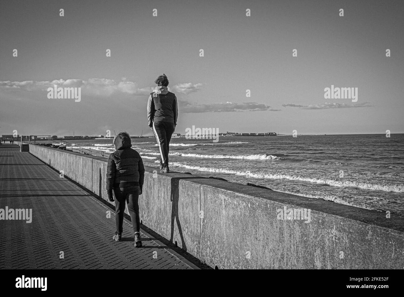 Jugendliche gehen auf Hartlepool's Seaton Promenade, England, Großbritannien Stockfoto