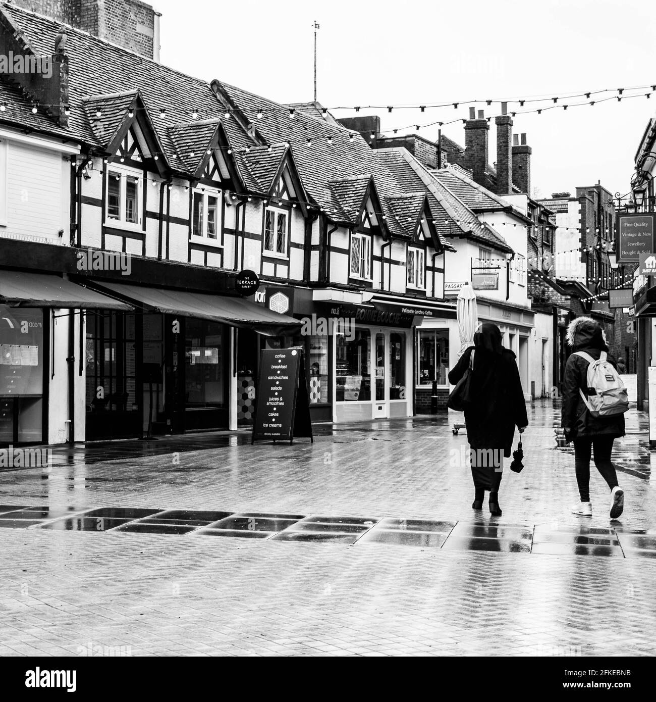 Kingston upon Thames, London Großbritannien, zwei Frauen, die an leeren geschlossenen Geschäften vorbeigehen Coronavirus Covid-19 Lockdown Wet Day Stockfoto